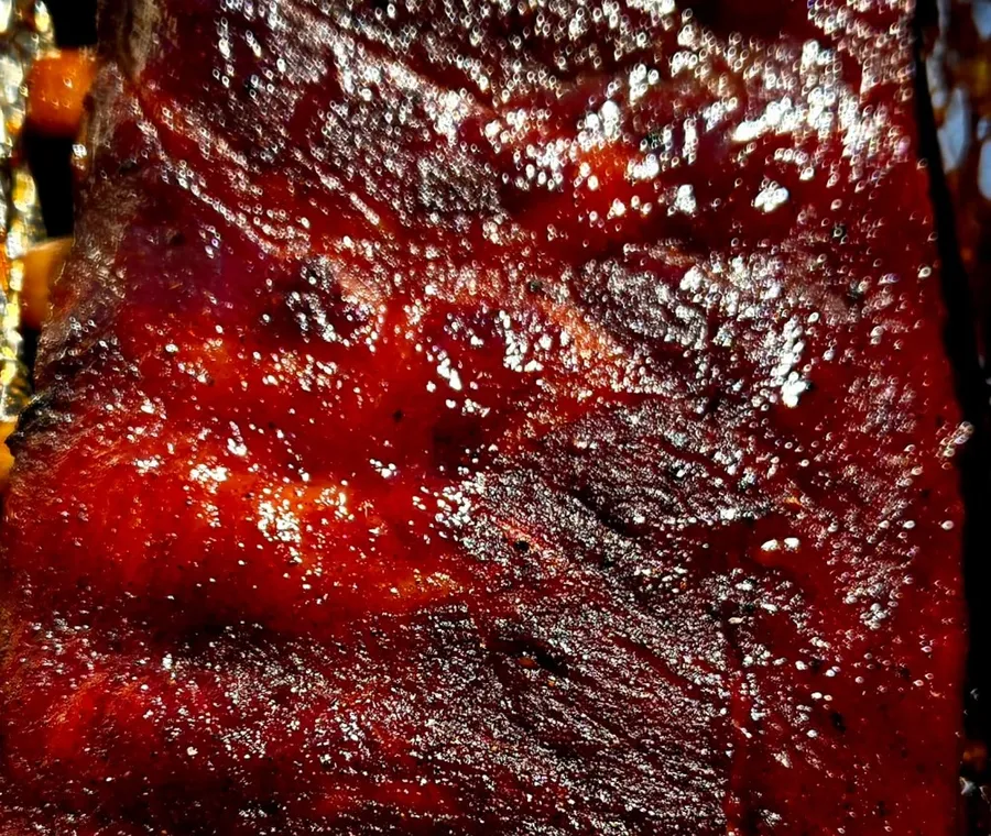 Brisket rubbed and seasoned, resting on the smoker before a long cook