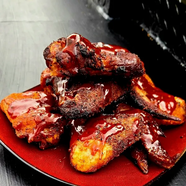Saucy smoked wings piled on a plate