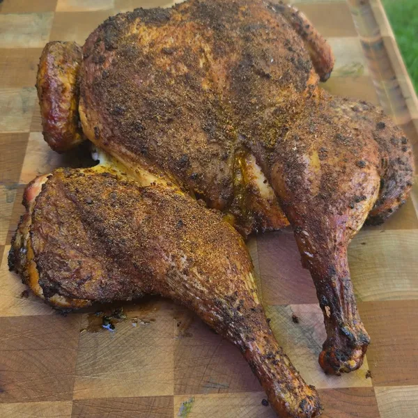 Smoked chicken quarters, rested on a cutting board