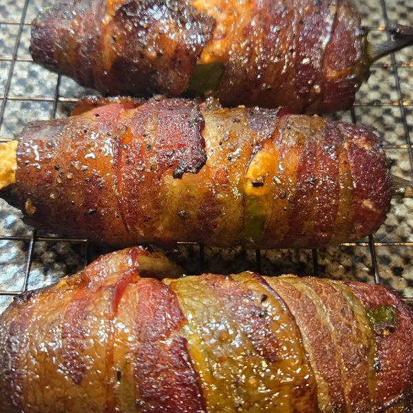 Bacon-wrapped stuffed jalapeño poppers fresh off the smoker