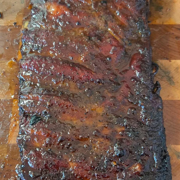 A glazed rack of ribs, sliced, with a deep smoke ring