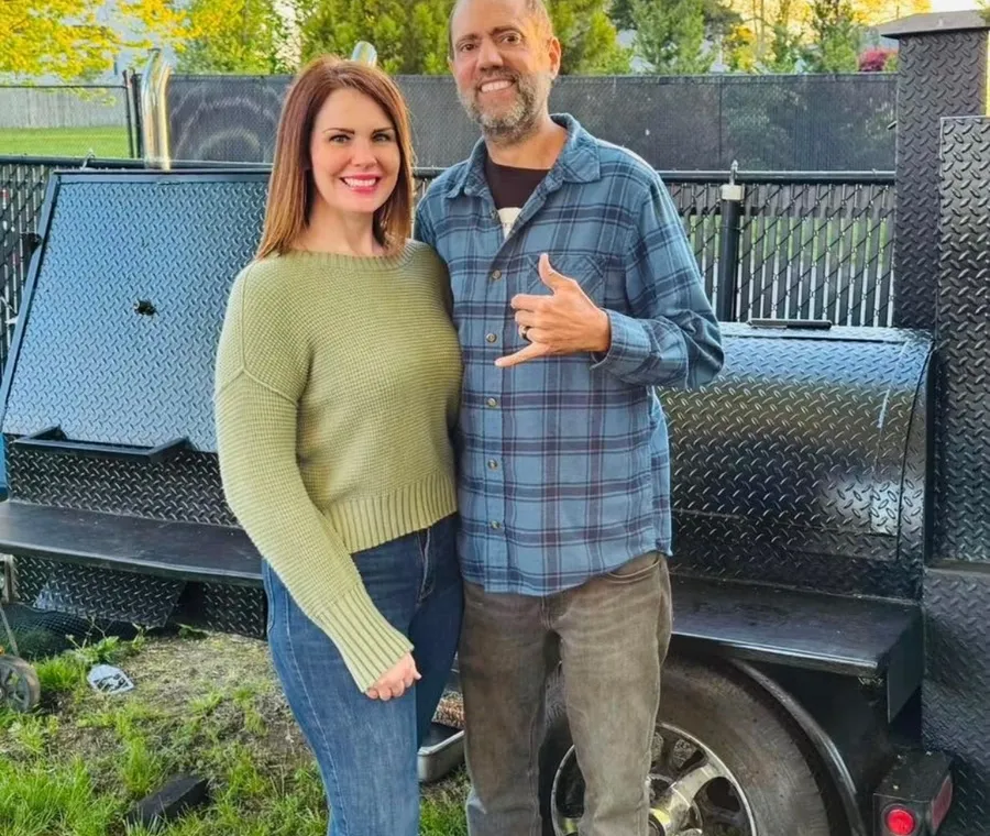 The Vanderwolf Smoke BBQ owners in front of their smoker trailer